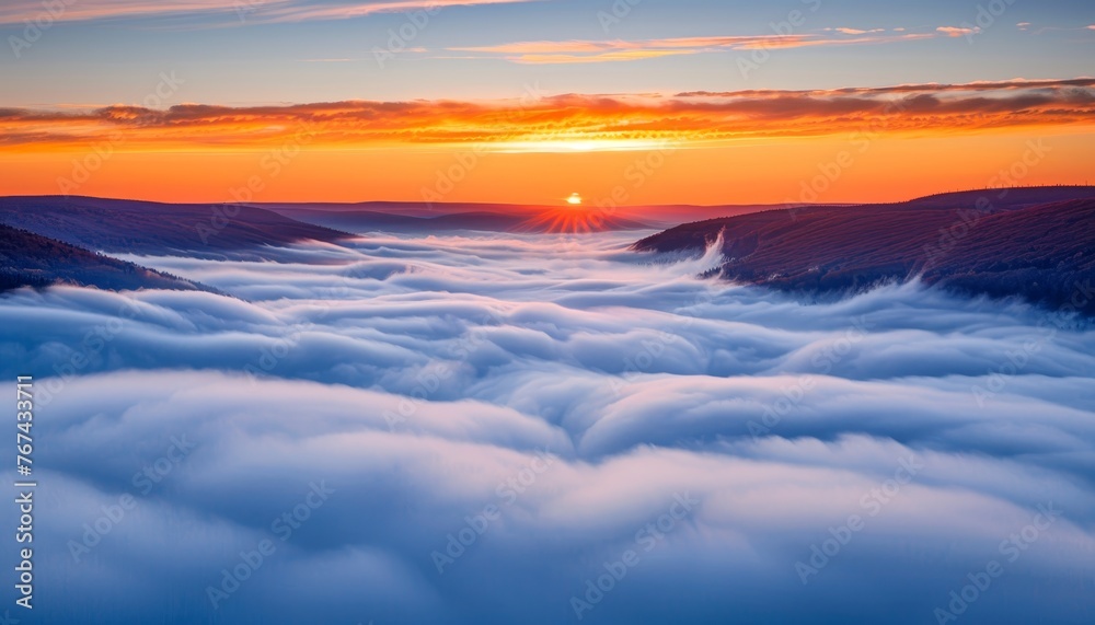 Majestic mountain sunrise in foggy morning with orange sky and clouds creating a beautiful landscape