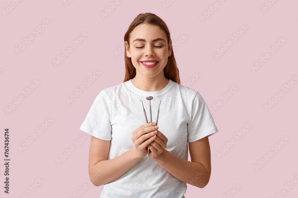 Female dentist with dental tools on pink background. World Dentist Day Female dentist with dental tools on pink background. World Dentist Day