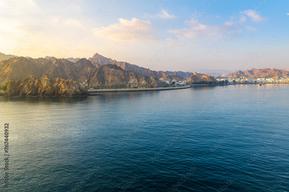 Early morning view from the sea of the old city, Mutrah Fort and Mutrah Corniche waterfront at the Port Sultan Qaboos of Muscat Oman along the Gulf of Oman in the Arabian Sea	