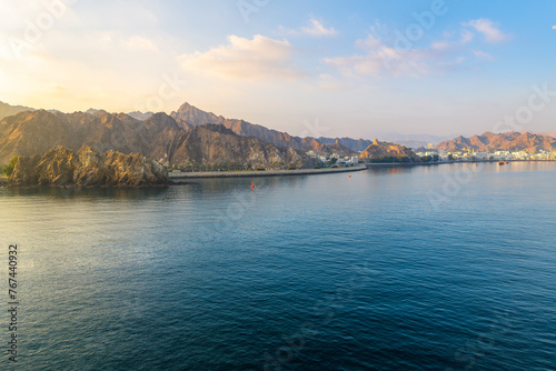 Early morning view from the sea of the old city, Mutrah Fort and Mutrah Corniche waterfront at the Port Sultan Qaboos of Muscat Oman along the Gulf of Oman in the Arabian Sea 