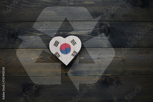 wooden heart with national flag of south korea near reduce, reuse and recycle sing on the wooden background. concept