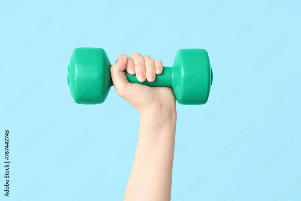 Female hand with dumbbell on color background, closeup - obrazy, fototapety, plakaty 