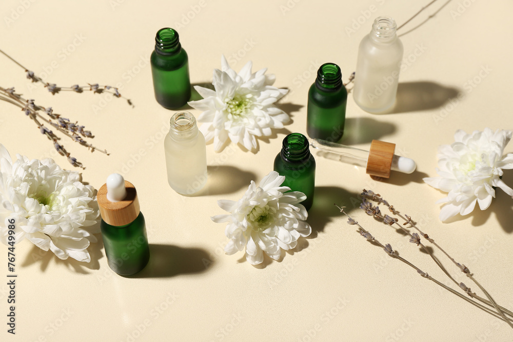 Composition with bottles of essential oil and flowers on color background