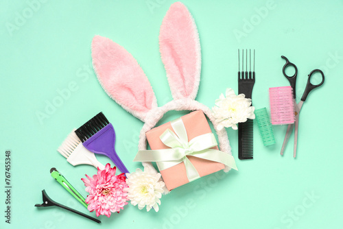 Composition with hairdresser's supplies, bunny ears and gift box on color background