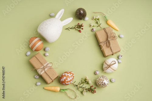 Canvas Print Beautiful wreath made of Easter eggs, flowers and gift boxes on green background