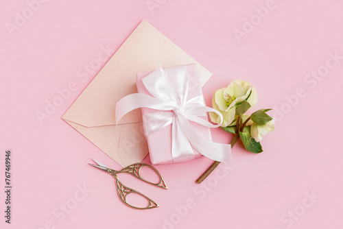 Gift box with beautiful flowers and envelope on pink background © Pixel-Shot