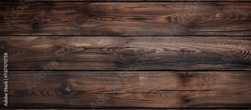 A closeup shot of a brown hardwood plank with wood stain  showcasing the intricate pattern of the wood grain. The blurred background adds depth to the image