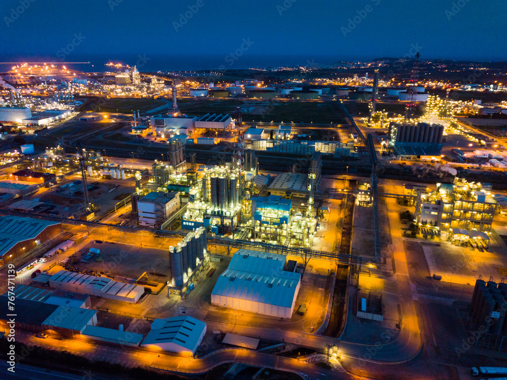 Night aerial panoramic view of large chemical plant located next to Salou city, Spain