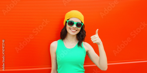 Summer portrait of happy smiling brunette young woman posing in yellow hat, green sunglasses