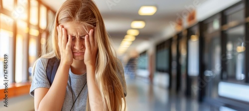 Teenage girl upset in school corridor, blurred background, facing learning difficulties, copy space