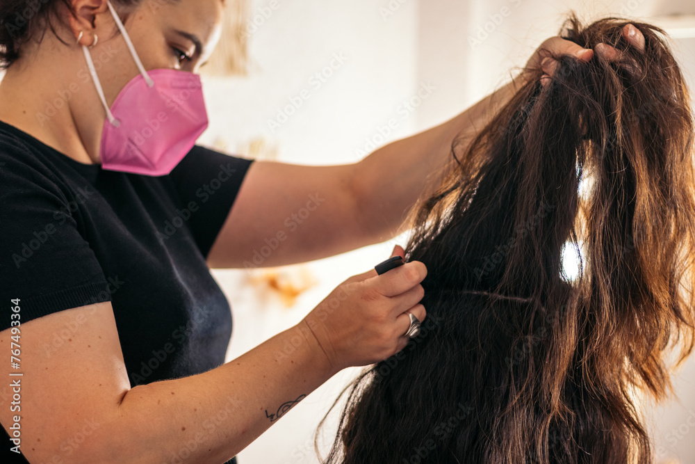 Fototapeta premium Hairdresser doing a woman's long hair