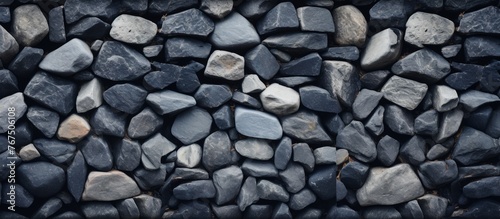 A close up of cobblestone rocks forming a pattern on a wall. These natural building materials are commonly used for flooring and road surfaces photo