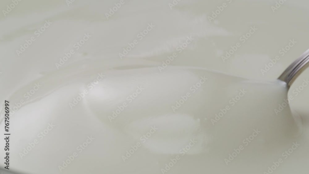 White creamy sauce texture close-up. Dip a spoon into white yogurt macro. Dairy products concept. White creamy sauce texture close-up. Dip a spoon into white yogurt macro. Dairy products concept.