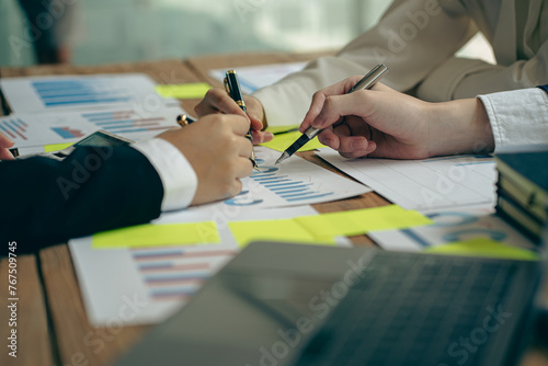 A team of analysts works on a financial data analysis dashboard on paper to use as market indicators for planning, strategic brainstorming, financial investments and marketing new business projects.