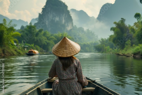 Woman in Vietnamese hat sitting in a riverboat photo