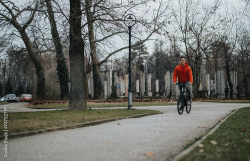 Wallpaper Mural Casual young man cycling through a tranquil park, enjoying nature on an overcast day. Torontodigital.ca