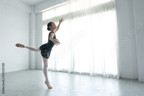 Little girl is practicing ballet in her bedroom at home, ballerina practicing classic choreography, ballet concept