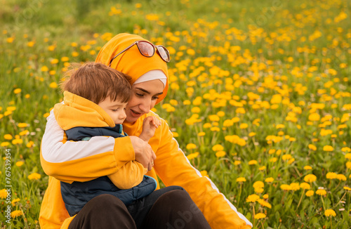 Tableau sur toile Happy Muslim family having fun mother and child boy playing together with dandelion in the flowering spring field