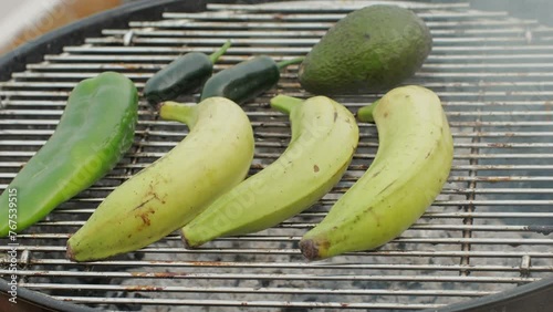 Grilled Banana on fire, latin american vegan grill with avocado and pepper, thai or Ecuadorian Street food. African traditional food on grill.  photo