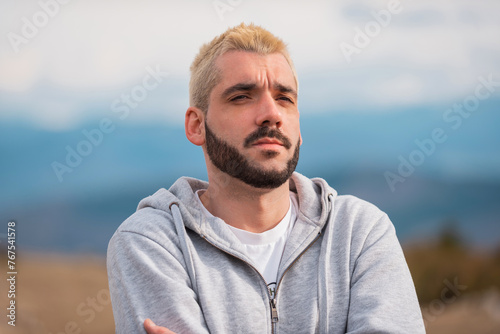 Portrait of a bearded thoughtful man outside.