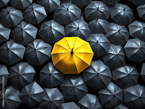 yellow umbrella against the background of many open dark umbrellas. top view. background abstraction. individuality concept