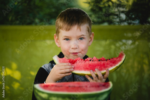 A little boy eats a watermelon.