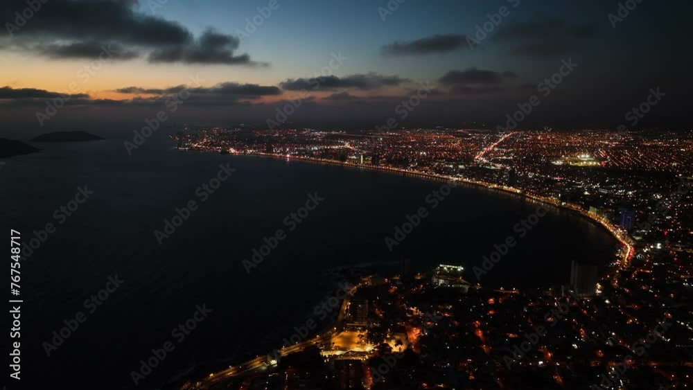 Aerial tracking shot following the coastline of Mazatlan, dramatic dusk in Mexico