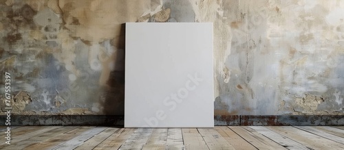 White canvas frame leaning against a concrete wall and wooden floor, perfect for inserting your own design with a mock-up template.