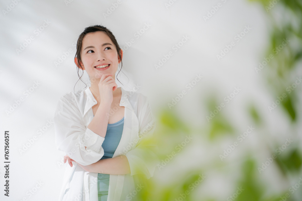 顎に手を当てて考える若い女性 顎に手を当てて考える若い女性