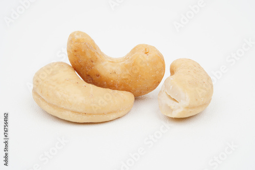Closeup of three tasty cashew nuts isolated background
