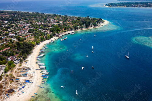 Aerial view of lines of wooden tourist boats on a sandy beach of a tropical island