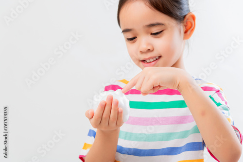 Cute Asian girl, holding foam, washing her face