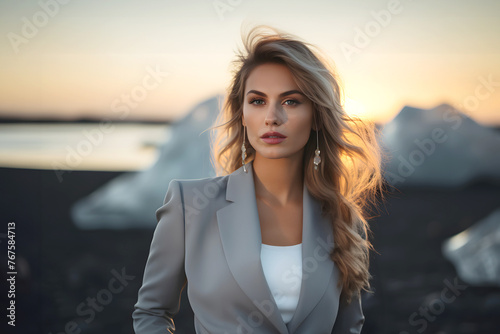 beautiful young fashionable woman on the black coast of iceland among the ice floes against the backdrop of sunset. © photosaint
