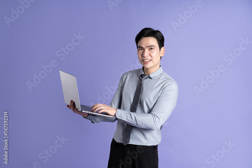 Portrait of Asian male businessman posing on purple background