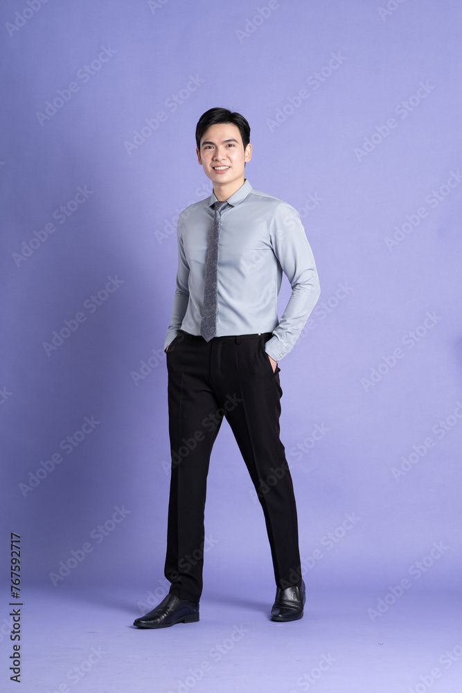 Portrait of Asian male businessman standing and posing on purple background Portrait of Asian male businessman standing and posing on purple background