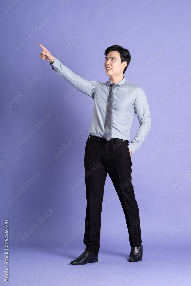 Portrait of Asian male businessman standing and posing on purple background Portrait of Asian male businessman standing and posing on purple background
