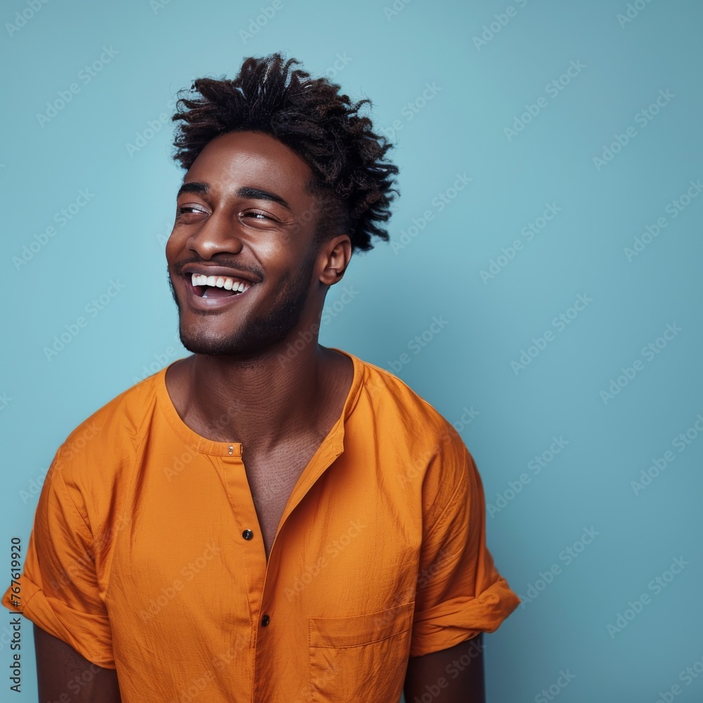 Obraz premium A man with dreadlocks is smiling and wearing an orange shirt with flowers on it