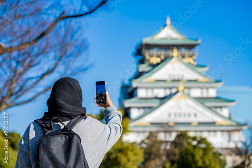 Travel, Muslim travel, Asian Muslim female tourist walking and visitor learning about history at Osaka Castle, Osaka Castle is one of the most famous landmarks in Japan and Osaka, holiday lifestyle.