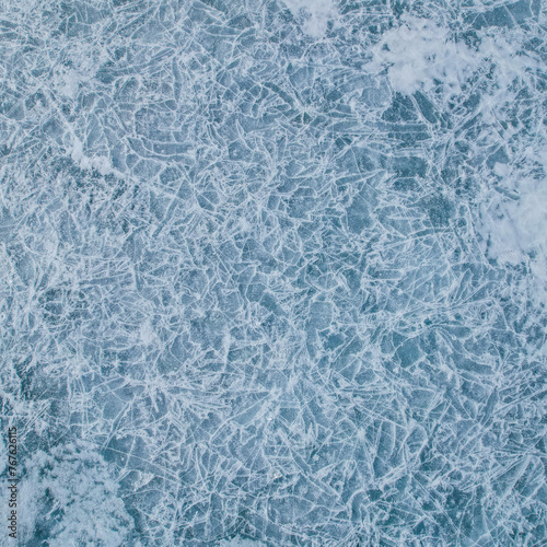 Cracks surface of the frozen lake of Baikal lake in winter season. ice texture cracks baikal, abstract background winter ice transparent blue. Selective focus. © Nikita