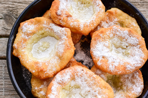 Traditional Bulgarian home made deep fried  patties  covered with sugar  оn rustic backgroud.Mekitsa or Mekica,  on wooden  rustic  background. Made of kneaded dough that is deep fried  photo