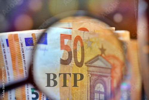 Bild auf Leinwand Magnifying glass over the pile of money with the text “BTP” translating as Italian government bonds