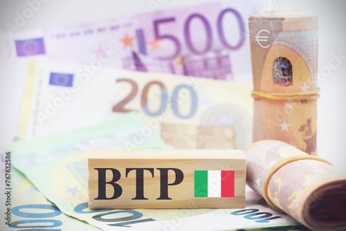 Bild auf Leinwand European banknotes with wooden cubes and Table with european banknotes as background with the text “BTP” translating as Italian government bonds