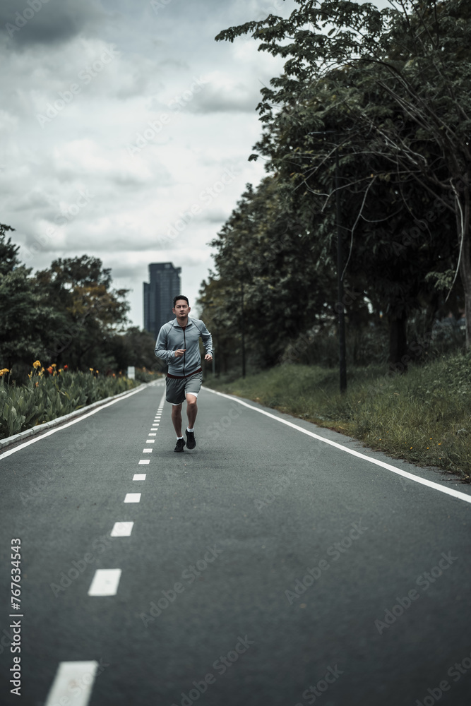 A man jogging in the city center park cardio workout, running. Health and Lifestyle in big city life concept. A man jogging in the city center park cardio workout, running. Health and Lifestyle in big city life concept.
