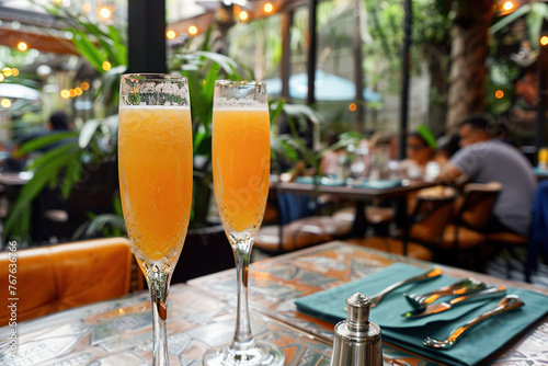 Mimosas served in champagne glasses  amidst a bustling brunch spot in resort.