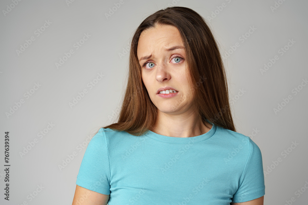 Portrait of thoughtful uncertain young casual girl on gray background Portrait of thoughtful uncertain young casual girl on gray background