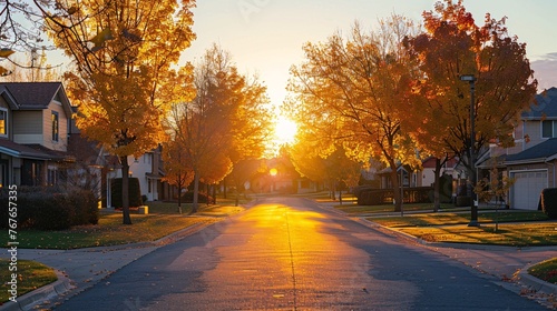 Tranquil residential road with homes and autumnal foliage at dusk.