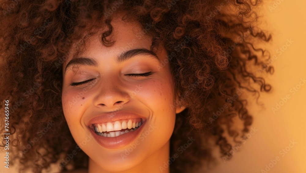 Happy laughing American African woman with her curly hair. Laughing curly woman in sweater touching her hair and looking at the camera Happy laughing American African woman with her curly hair. Laughing curly woman in sweater touching her hair and looking at the camera