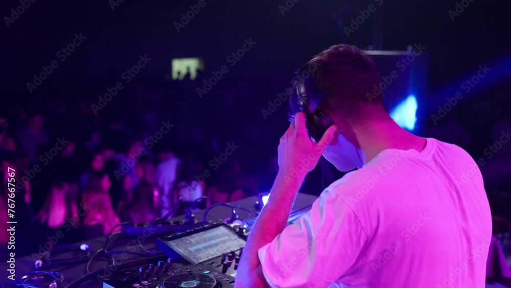 DJ dancing while working in a crowded nightclub