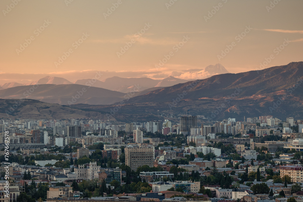 View of Tbilisi from the surrounding hills. In the background you can see the Caucasus Mountains. A warm autumn day in the capital of Georgia.