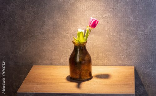 Flower in a vase on a night table in hotel room